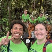 Kids smiling with green shirts on in a selfie