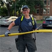 woman holding fire hose and smiling at camera